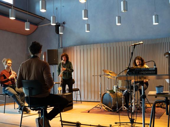 Blick auf die Bühne des Kammermusiksaals mit einer Gruppe von STudierenden, die für eine Improvisation proben