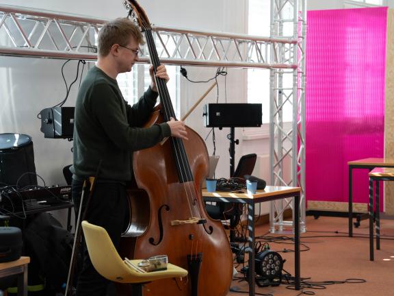 Blick auf einen Kontrabassisten, der mit Hilfe technischer Unterstützung im ehemaligen Bundesbankgebäude improvisiert