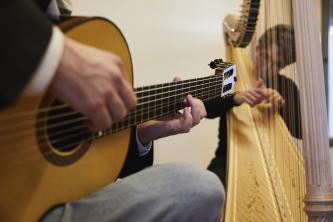 Blick auf zwei Dozierende der MHL, die Gitarre und Harfe zusammen spielen.