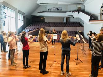 Blick auf eine Gruppe von musizierenden Querflötenspieler von der Bühne des Großen Saals der MHL in den Zuschauerraum